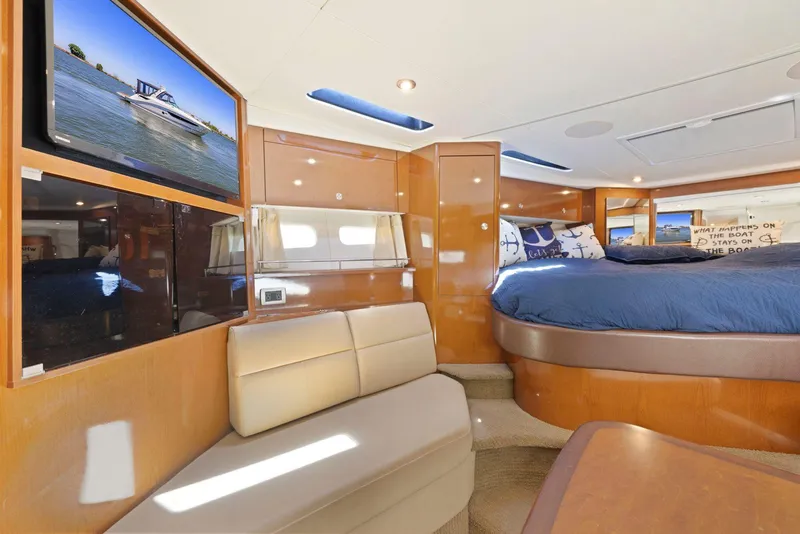 Slide: The Image of 2014 Sea Ray 350 Sundancer cabin interior with bed, seating, and TV. - 21