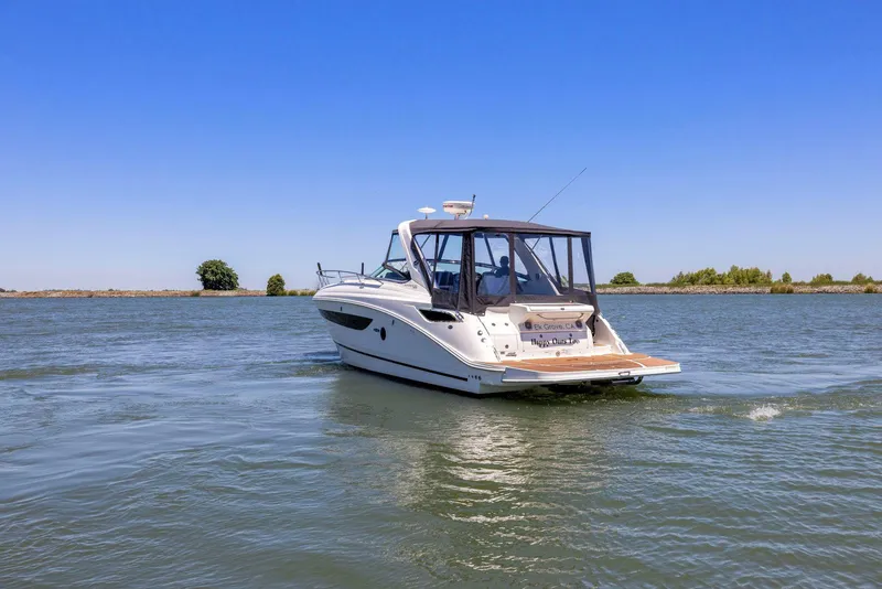 Slide: The Image of 2014 Sea Ray 350 Sundancer cruising on a calm lake under clear blue skies. - 4