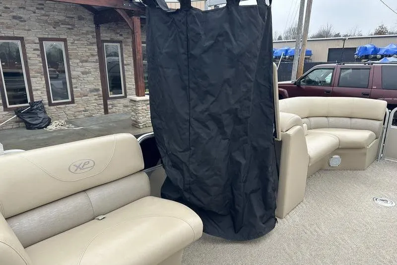 Slide: The Image of 2012 Xcursion X23RF boat interior with beige seating and privacy curtain. - 13