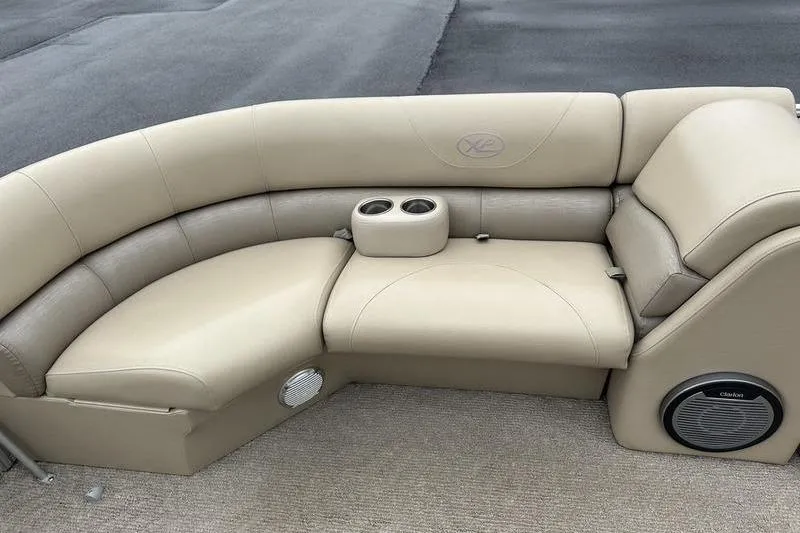 Slide: The Image of 2012 Xcursion X23RF boat seating with beige upholstery and built-in cup holders. - 15
