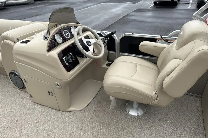 Slide: The Image of 2012 Xcursion X23RF boat interior with beige captain's chair and control panel. - 17