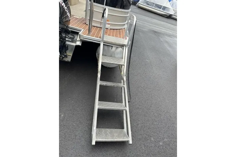 Slide: The Image of Aluminum boat ladder on 2012 Xcursion X23RF pontoon, docked on asphalt surface. - 4
