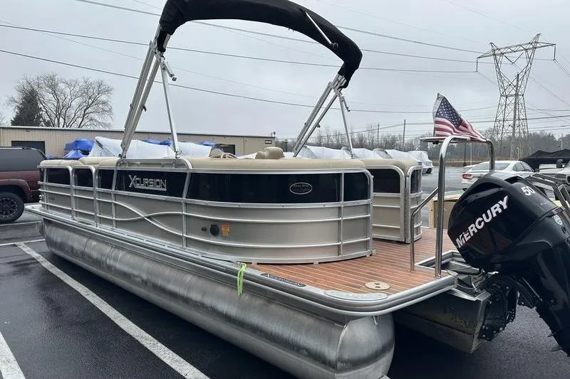 Slide: The Image of 2012 Xcursion X23RF pontoon boat with Mercury engine in a parking lot. - 6