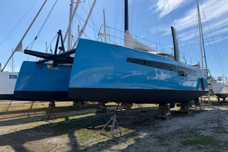 Slide: The Image of 2025 C-Catamarans 48 in dry dock, sleek blue hull, modern design. - 10
