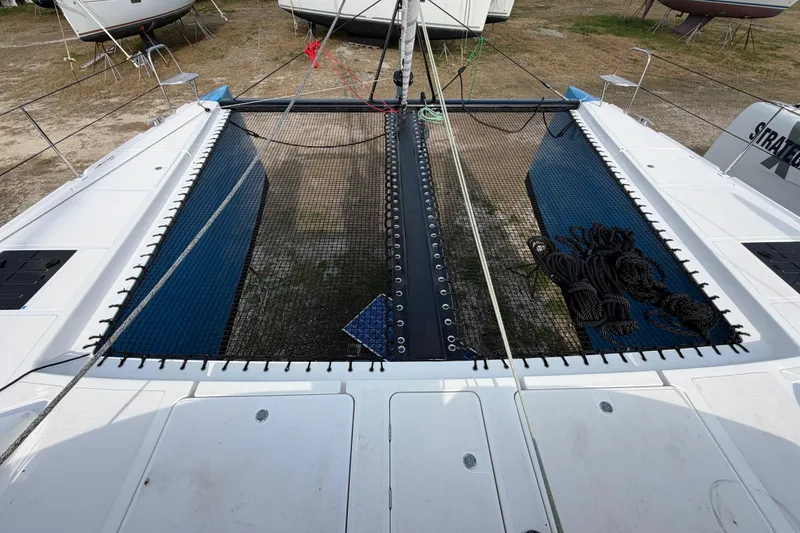 Slide: The Image of 2025 C-Catamarans 48 deck with netting and ropes, docked on land. - 100