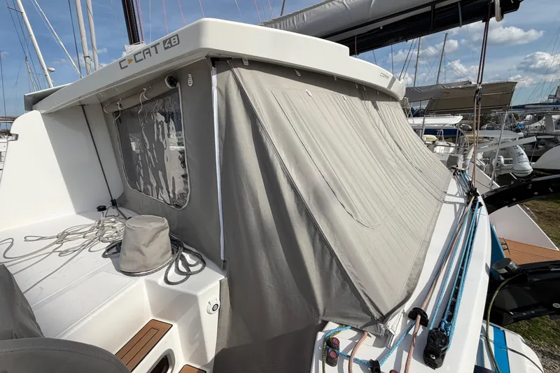 Slide: The Image of 2025 C-Catamarans 48 with covered deck, docked at marina under clear sky. - 13