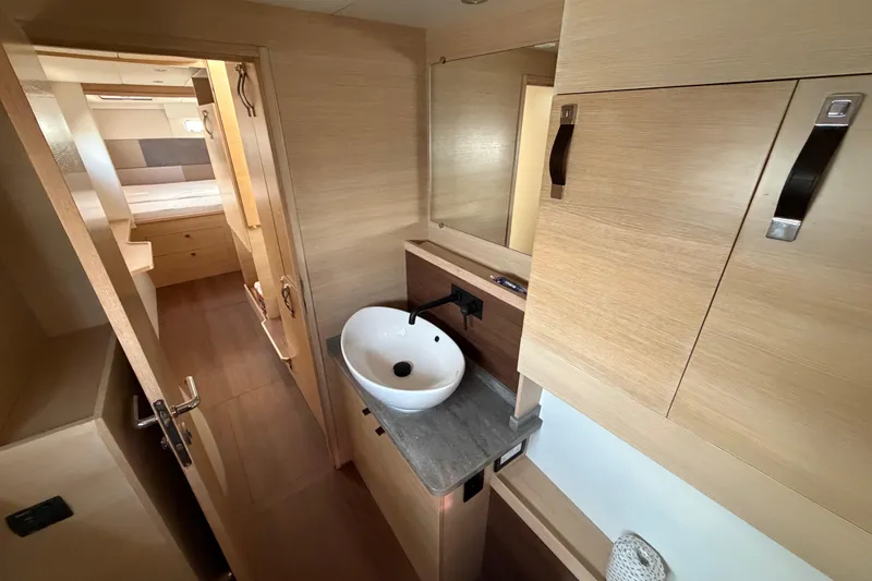 Slide: The Image of Modern bathroom interior of 2025 C-Catamarans 48, featuring sleek wood finishes and a stylish sink. - 32
