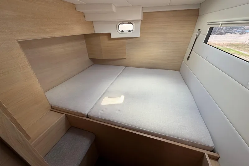 Slide: The Image of 2025 C-Catamarans 48 interior cabin with modern wood finish and cozy bedding. - 40
