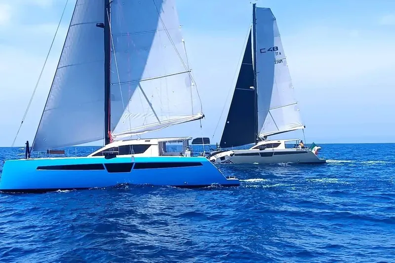 Slide: The Image of Two C-Catamarans 48 sailing on open sea, 2025 model, under clear blue skies. - 5