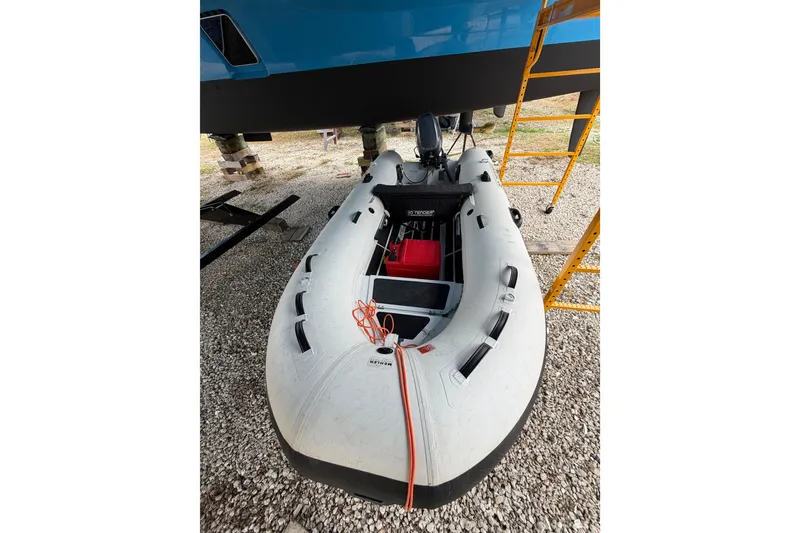 Slide: The Image of Inflatable boat under a 2025 C-Catamarans 48, on gravel with scaffolding nearby. - 50