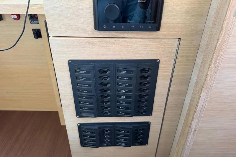 Slide: The Image of Control panel on 2025 C-Catamarans 48, featuring labeled switches and a Fusion audio system. - 62