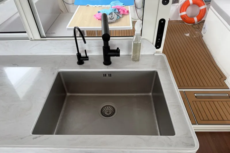 Slide: The Image of Modern kitchen sink on 2025 C-Catamarans 48 yacht with sleek design and wooden deck. - 66