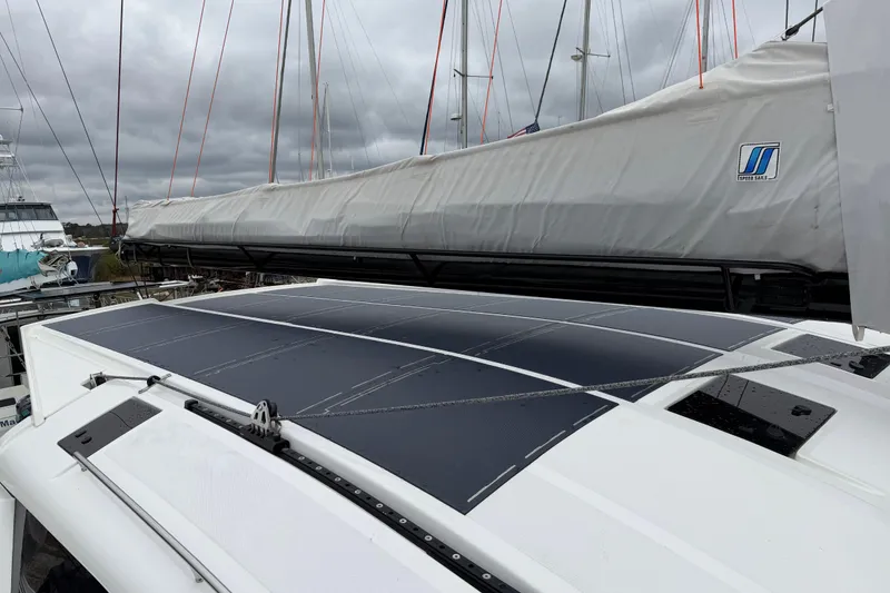 Slide: The Image of 2025 C-Catamarans 48 with solar panels and covered sail, docked under cloudy skies. - 83