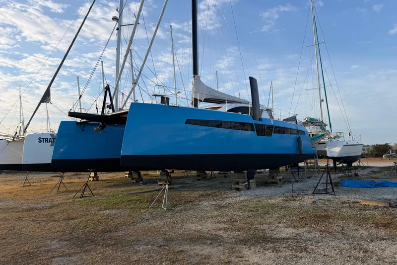 Slide: The Image of 2025 C-Catamarans 48 sailboat on land, blue hull, clear sky background. - 9