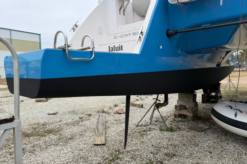 Slide: The Image of 2025 C-Catamarans 48 in dry dock, blue hull, ladder, and rudder visible. - 95