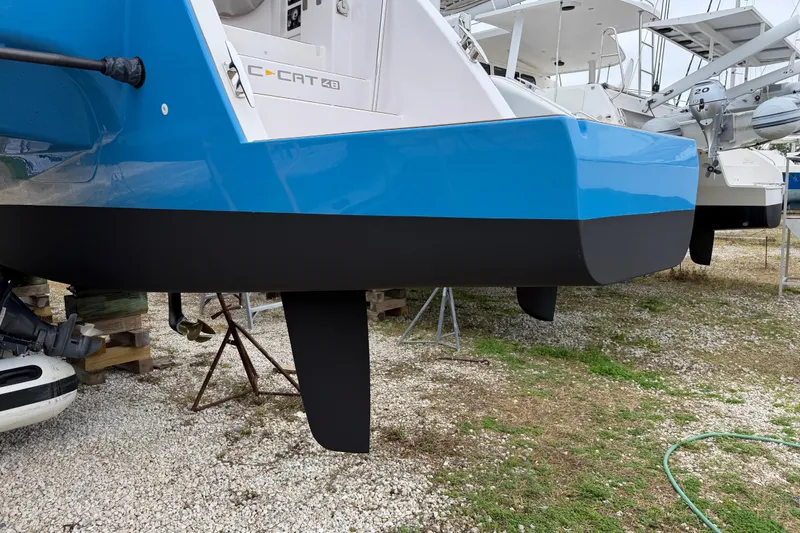 Slide: The Image of 2025 C-Catamarans 48 with blue and black hull, displayed on gravel. - 96