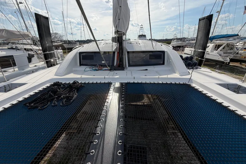 Slide: The Image of 2025 C-Catamarans 48 yacht with spacious deck and netting, docked in a marina. - 97