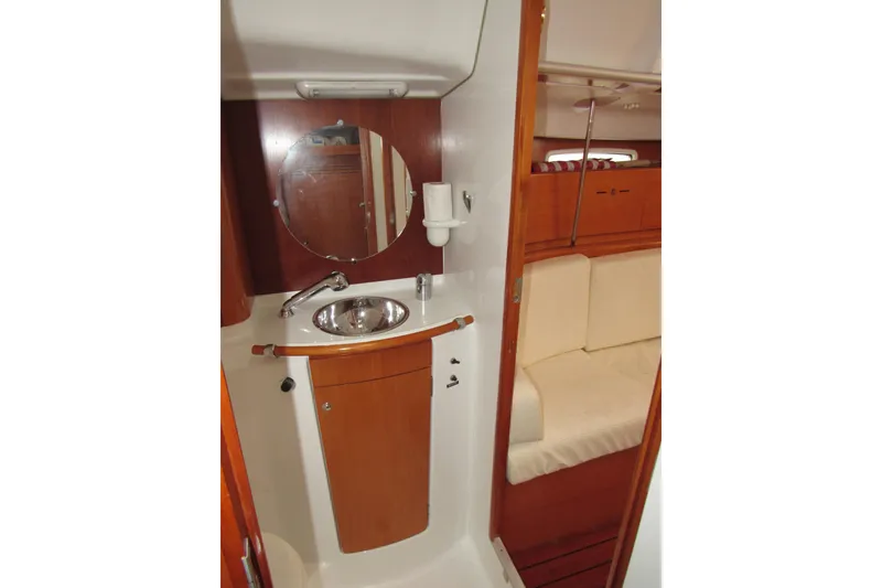 Slide: The Image of 2002 Beneteau First 40.7 yacht bathroom with sink, mirror, and wooden cabinetry. - 10