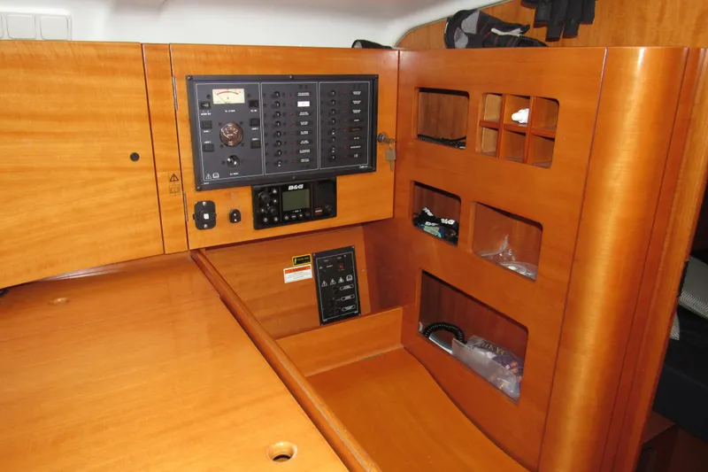 Slide: The Image of Interior view of 2002 Beneteau First 40.7 sailboat with wooden cabinetry and control panel. - 14