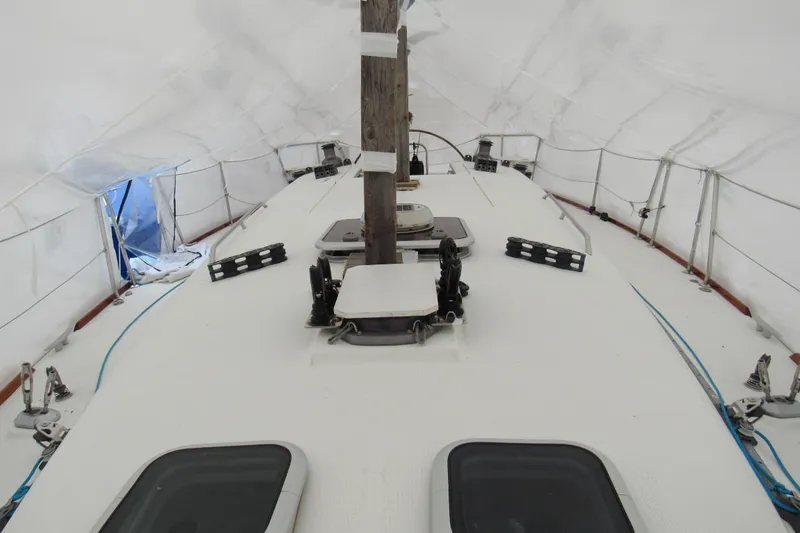 Slide: The Image of Beneteau First 40.7 sailboat deck under cover, showcasing rigging and hatches, 2002 model. - 30