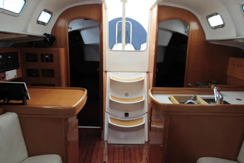 Slide: The Image of Interior of 2002 Beneteau First 40.7 sailboat with wood finish and compact kitchen. - 4