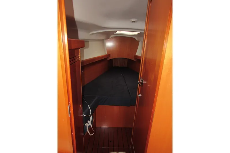 Slide: The Image of Beneteau First 40.7 (2002) cabin interior with wooden finish and black bedding. - 5