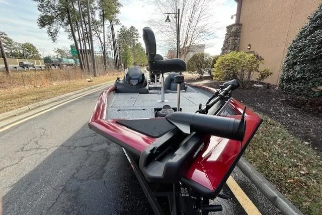 Slide: The Image of 2024 Tracker Pro Team 175 TXW boat parked on a road, surrounded by trees. - 3
