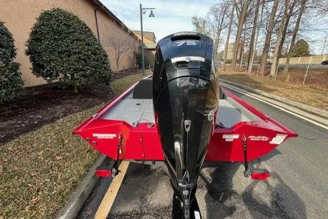 Slide: The Image of 2024 Tracker Pro Team 175 TXW boat with Mercury engine, parked outdoors. - 6
