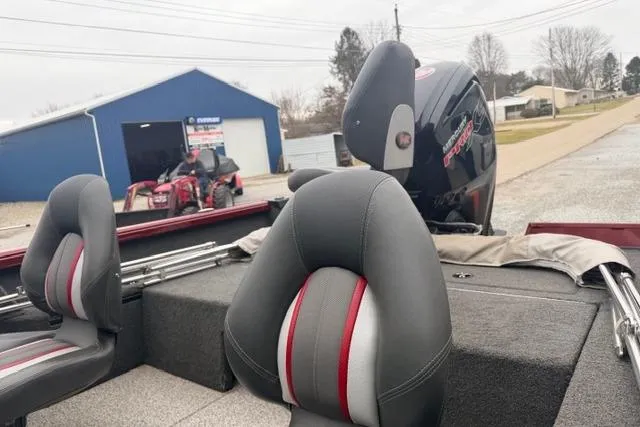 Slide: The Image of 2017 Ranger VS1780 boat interior with seats and motor, parked near a blue building. - 7