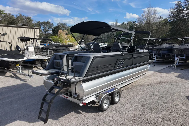 Slide: The Image of 2026 Viaggio Diamante D24U pontoon boat on trailer, parked outdoors under blue sky. - 2