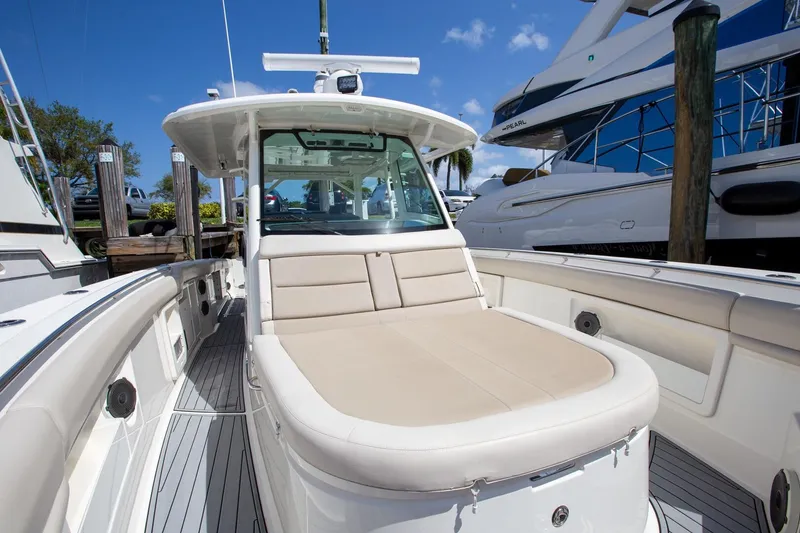Slide: The Image of 2019 Boston Whaler 380 Outrage boat with spacious deck and seating, docked under clear skies. - 6