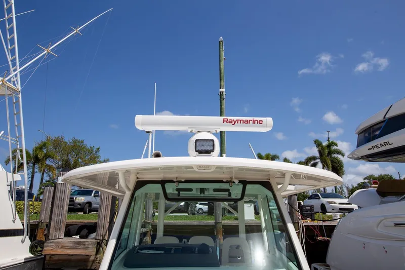Slide: The Image of 2019 Boston Whaler 380 Outrage with Raymarine radar, docked under clear blue sky. - 9