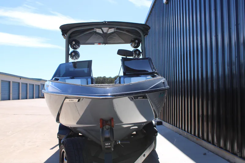 Slide: The Image of 2020 Malibu Wakesetter 25 LSV boat parked near storage units. - 4