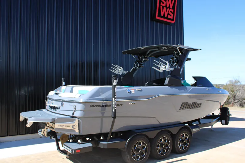 Slide: The Image of 2020 Malibu Wakesetter 25 LSV boat on trailer, parked outside a building. - 6