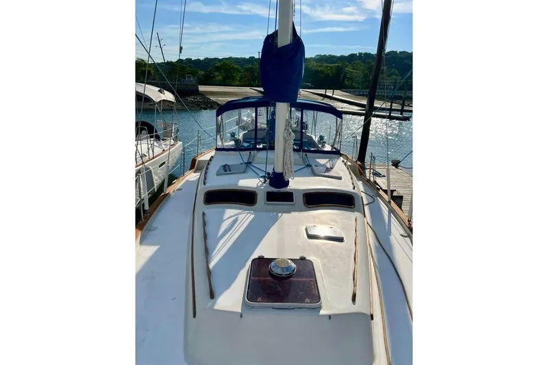 Slide: The Image of 1987 Irwin 43 Mk II Cruiser sailboat docked at marina under clear blue sky. - 11