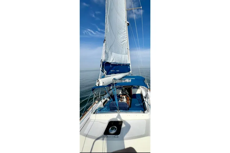 Slide: The Image of 1987 Irwin 43 Mk II Cruiser sailing on calm waters under a clear blue sky. - 12