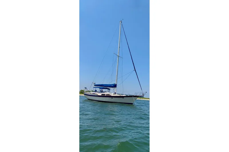 Slide: The Image of 1987 Irwin 43 Mk II Cruiser sailboat on calm water under clear blue sky. - 13