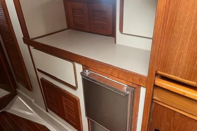 Slide: The Image of Interior of 1987 Irwin 43 Mk II Cruiser with wooden cabinetry and compact fridge. - 33