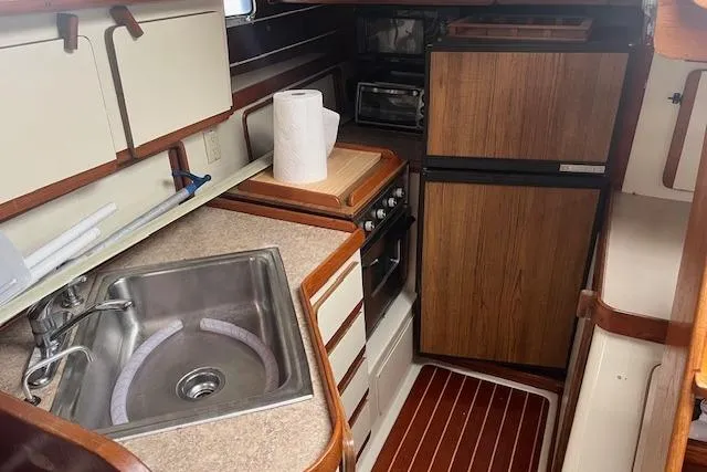 Slide: The Image of 1987 Irwin 43 Mk II Cruiser galley with sink, stove, and wood accents. - 34
