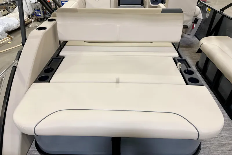 Slide: The Image of 2026 Godfrey Sweetwater 2286 SFL boat interior with beige seating and cup holders. - 4