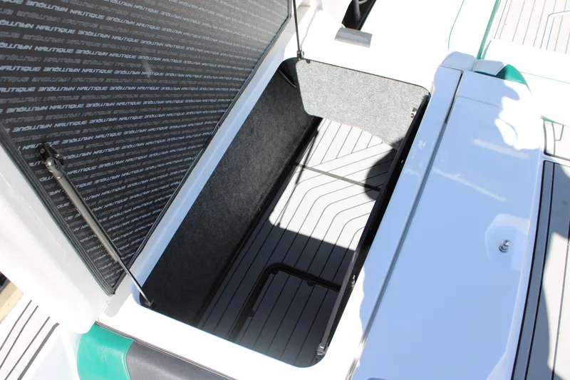 Slide: The Image of 2021 Nautique Super Air Nautique G21 storage compartment with open hatch and sleek interior design. - 11