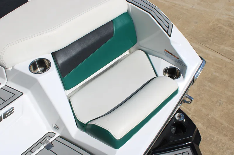 Slide: The Image of 2021 Nautique Super Air Nautique G21 boat seating with cup holders, white and green upholstery. - 9