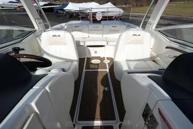 Slide: The Image of 2008 Sea Ray SLX 250 boat interior with white seating and wood flooring. - 15