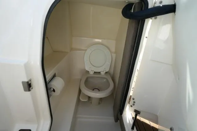 Slide: The Image of 2008 Sea Ray SLX 250 boat interior with compact marine toilet and paper holder. - 18