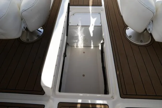 Slide: The Image of 2008 Sea Ray SLX 250 boat interior with open storage compartment and white seating. - 19