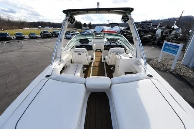 Slide: The Image of 2008 Sea Ray SLX 250 boat with spacious seating and sleek design in a parking lot. - 8