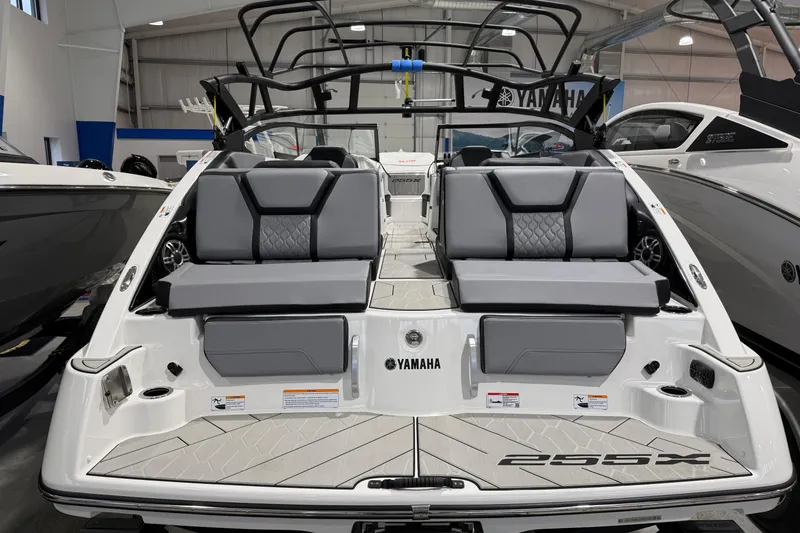 Slide: The Image of 2026 Yamaha Boats 255XE interior with sleek seating and modern design in a showroom. - 3