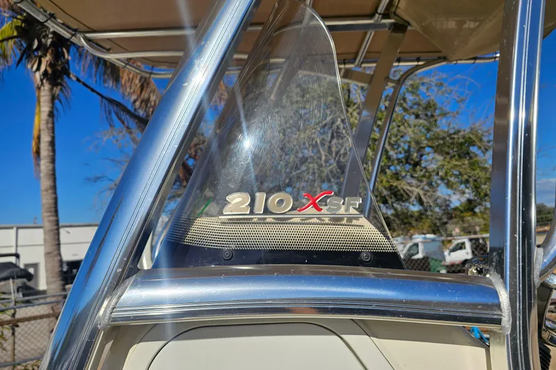 Slide: The Image of 2016 Scout 210 XSF boat windshield with logo, sunny outdoor setting. - 18