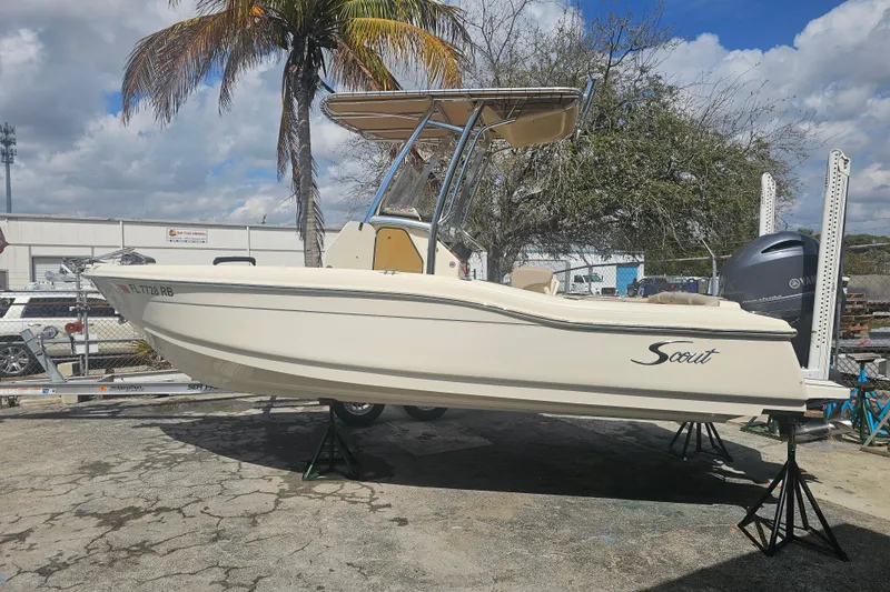 Slide: The Image of 2016 Scout 210 XSF boat on stands, outdoor setting, palm tree background. - 19