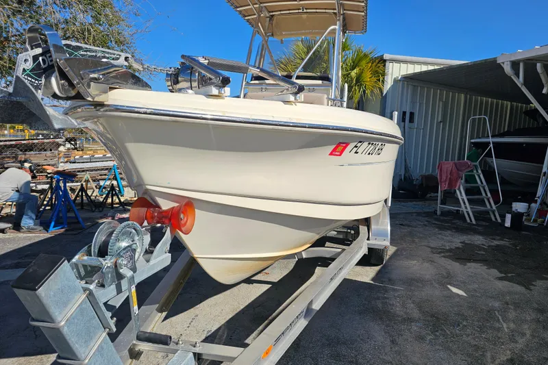 Slide: The Image of 2016 Scout 210 XSF boat on trailer in sunny outdoor setting. - 2